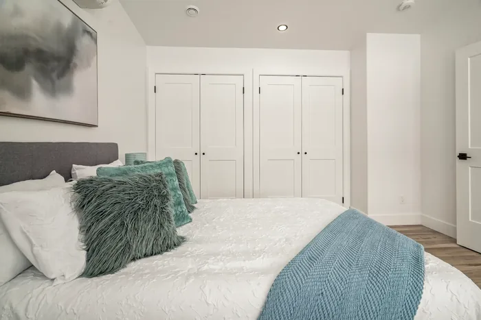 The master bedroom of a finished REDI-HOME, showing two sets of double closet doors along the wall opposite the bed.